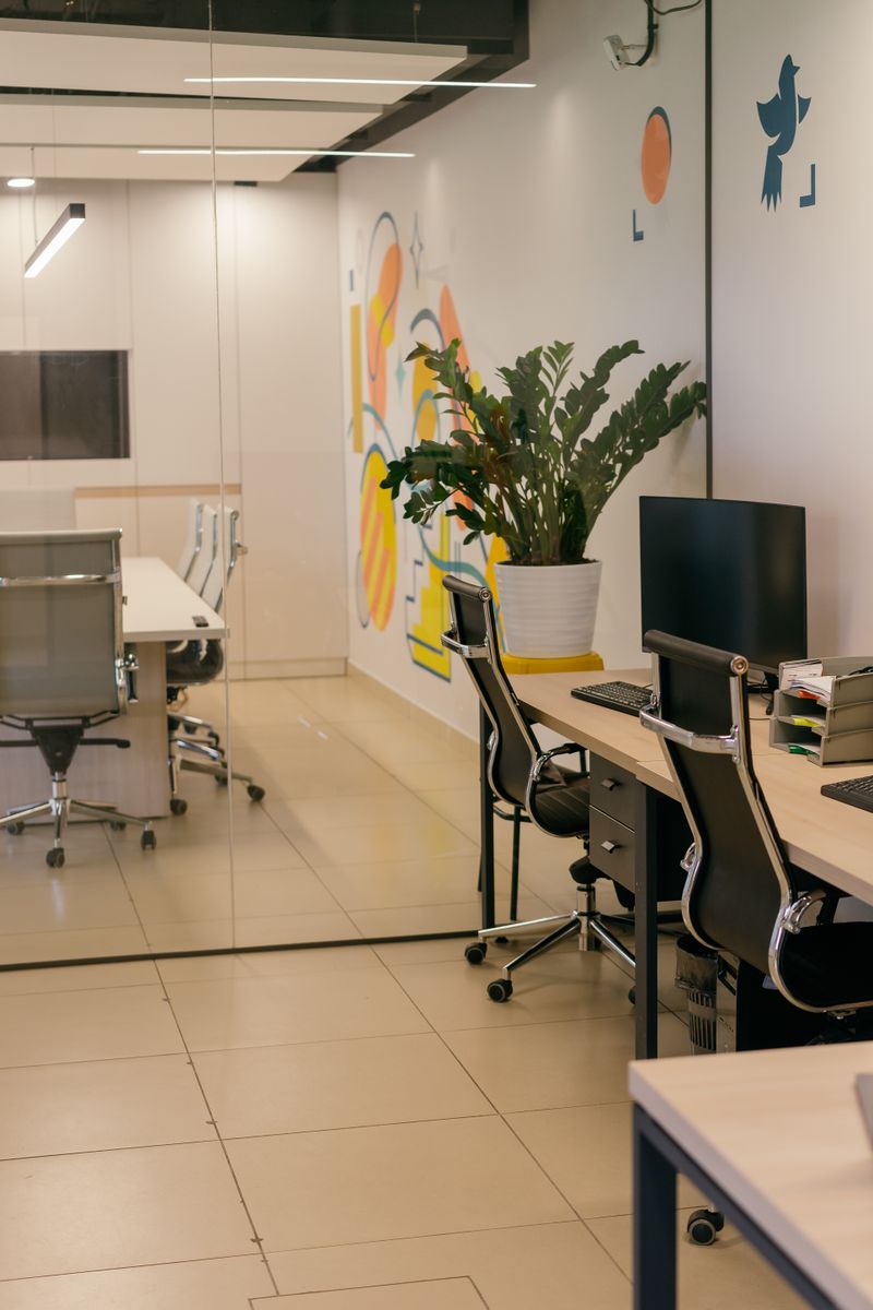 Modern commercial office with glass partitions, tidy workstations and polished floors.