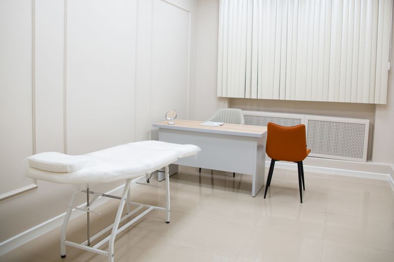Spotless medical exam room with a clean treatment table and neatly arranged linens.